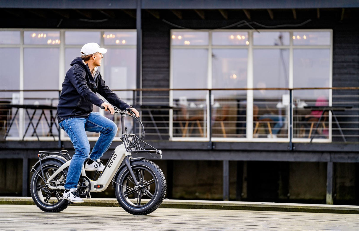 Mann fährt ein kompaktes E-Bike mit breiten Reifen in urbaner Umgebung