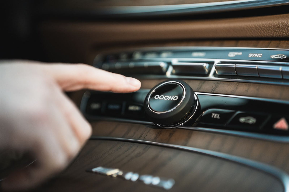 OOONO Verkehrsalarm im Auto am Armaturenbrett mit Finger zur einfachen Bedienung während der Fahrt